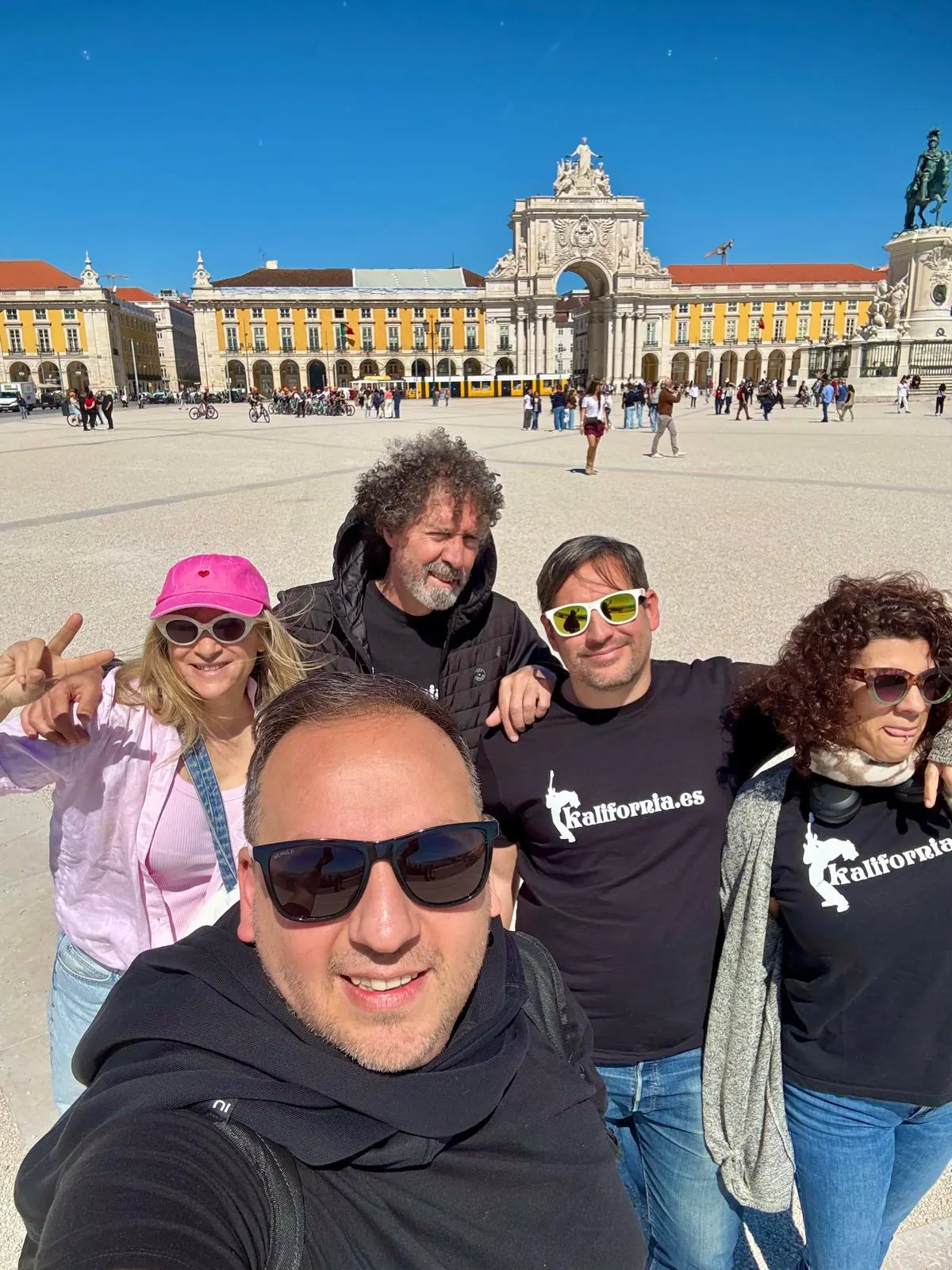 Músicos de Orquesta Kalifornia en la Praça do Comércio, con el Arco da Rua Augusta detrás