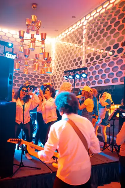 Orquesta Kalifornia en el evento de empresa de Metricool, con el equipo disfrazado cantando en el escenario